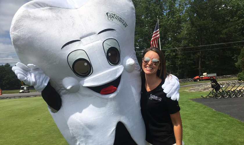 Doctor Chadbourne smiling with person in tooth mascot costume