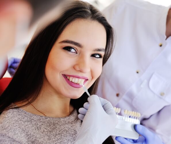 Young woman trying on dental veneers from her cosmetic dentist