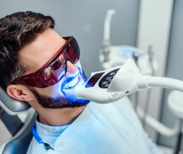 Man getting his teeth professionally whitened in dental office