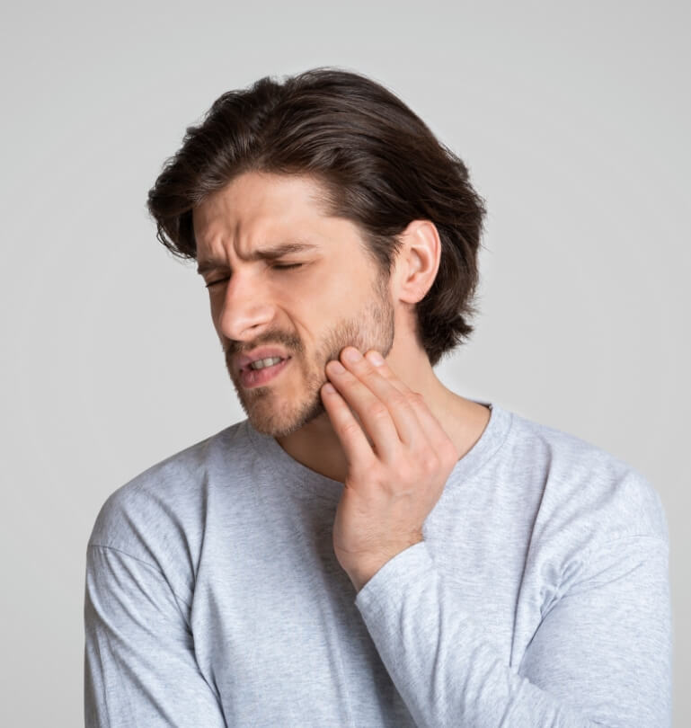 Man holding his cheek in pain needing emergency dentist in Falmouth