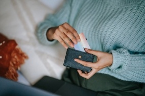 Person taking a payment card out of their wallet