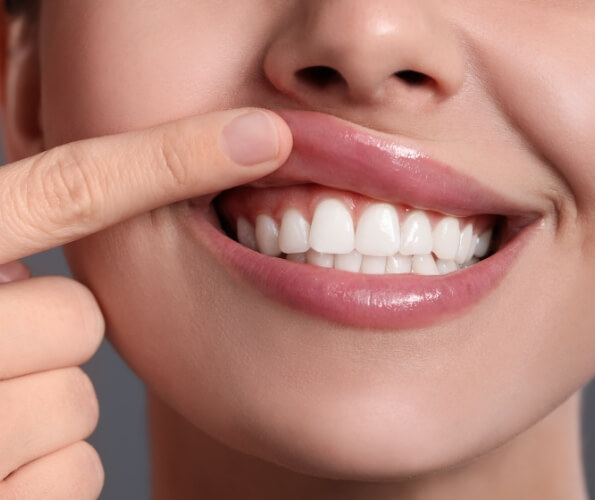 Person pointing to their gums