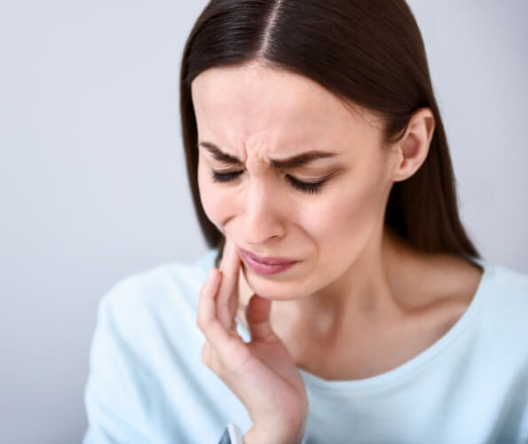 Woman touching the side of her face in pain