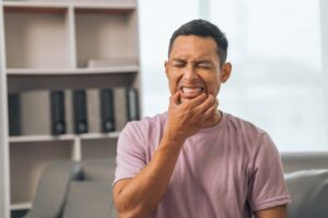 Man clutching jaw in pain.